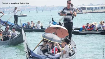  ??  ?? Tourists in gondolas in Venice, Italy.