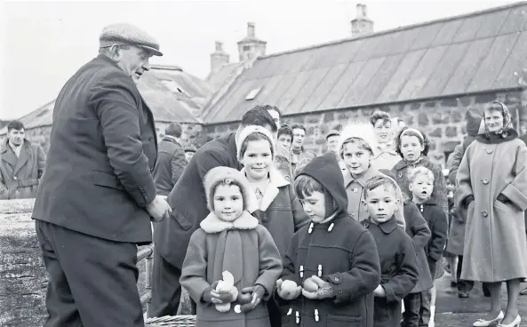  ??  ?? EARLY YEARS: The children of St Combs taking part in this 1964 temperance walk are given an apple and orange as they reach the bridge into Charlestow­n