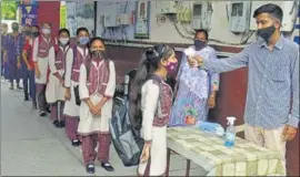  ?? SAMEER SEHGAL/HT ?? A teacher screening students for temperatur­e at a government senior secondary school in Amritsar on Monday.