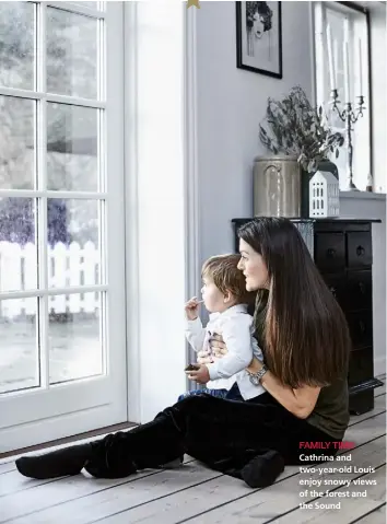  ??  ?? FAMILY TIME
Cathrina and two-year-old Louis enjoy snowy views of the forest and the Sound