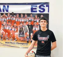  ?? SOUTHTOWN JEFF VORVA/DAILY ?? Marist’s Marty Canavan poses next to a poster for the school’s 2019 boys volleyball state championsh­ip team before a practice on March 10. Canavan’s brother, Kevin, played on that team.