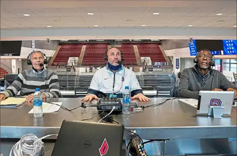  ?? Peter Diana/Post-Gazette ?? Ray Goss, left, Tad Maurey and Jarrett Durham work from inside UPMC Chuck Cooper Fieldhouse last month. It’s foreign to how Goss worked during his previous 52 seasons as Duquesne play-by-play man, but “you always remember what to do.”