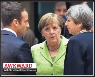  ??  ?? AWKWARD With Merkel and France’s Macron
