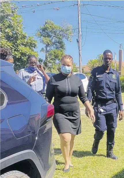  ?? (Photo: Akera Davis) ?? National Commercial Bank employee Khadene Thomas (centre) is escorted to court on Friday to answer fraud charges.