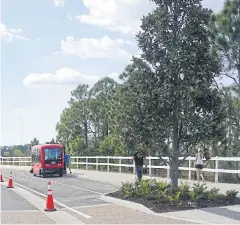  ?? AFP ?? Visitors walk on a brand new sidewalk near a driverless shuttle bus.