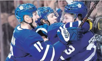  ?? FRANK GUNN THE CANADIAN PRESS FILE PHOTO ?? Toronto Maple Leafs defenceman Travis Dermott, right, is mobbed by teammates William Nylander and and Zach Hyman after scoring his first career goal Jan. 31.