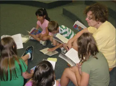  ??  ?? RSVP volunteer Linda Belinsky works with a group of students to practice reading.