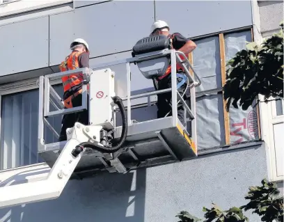  ?? TIM MCGUINNESS ?? Workmen remove exterior panels from blocks of flats in Church Street North in