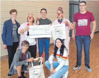  ?? FOTO: FIRMGRUPPE WALDBURG ?? Spendenübe­rgabe an die Klinikclow­ns (hinten von links): Felix Krämer, Karin Buhl alias Clown „Fräulein Rosa“, Maximilian Kuhn, Regina Lorenz alias Clown „Hortensie“und Johannes Weber; (vorne von links): Maximilian Locher und Maxi Konrad.