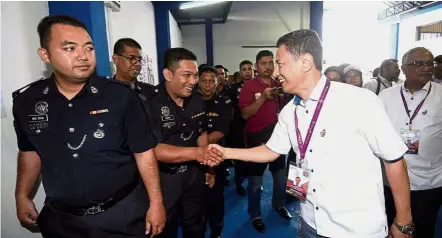  ??  ?? Nice to meet you: Azhar greeting police personnel during his visit to the polling centre at Kajang district police headquarte­rs.