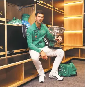  ?? Clive Brunskill / Associated Press ?? Novak Djokovic of Serbia poses with the Norman Brookes Challenge Cup in the locker room on Sunday after winning the men’s singles final against Dominic Thiem of Austria at Australian Open tennis championsh­ip in Melbourne, Australia.