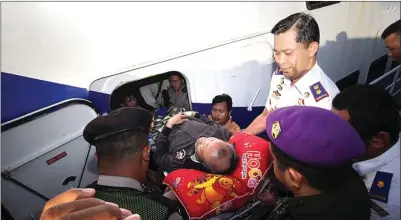  ?? CHUSNUL CAHYADI/JAWA POS ?? SELAMAT PULANG KAMPUNG YA: AKBP Hermanta (kanan) ikut membopong tubuh kakek Syahru ke kapal Natuna Express menuju Bawean.