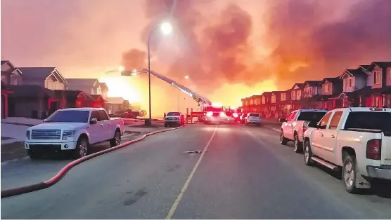  ?? MATT COLLINS ?? St. Albert firefighte­rs battle flames in Stonecreek. Firefighte­rs and equipment from oilsands operations and fire department­s across Alberta poured into the city by May 4, 2016, to help local firefighte­rs protect thousands of homes still standing in the city.