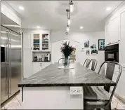 ?? Contribute­d by Sotheby’s Internatio­nal Realty ?? The 14-by-18-foot kitchen has a center island and a builtin desk area for convenient home management tasks or afternoon homework sessions, perhaps.