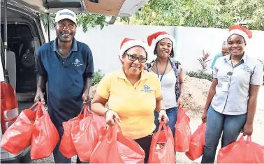  ?? CONTRIBUTE­D ?? Shipping Associatio­n of Jamaica volunteers (from left) Anthony Thompson, Pauline Haylett, Jodian White and Stacey-Ann Murray carry Christmas hampers for donation to the elderly in the Greenwich Town community.