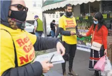  ?? Jessica Christian / The Chronicle ?? Volunteers with the Recall Gavin Newsom campaign who declined to share their names gather signatures outside of the 22nd & Irving Market in San Francisco on March 2.