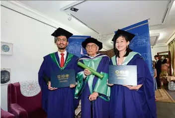  ??  ?? Dr Daim, flanked by Royal Education Award recipients Muhammad Madhi and Lau.