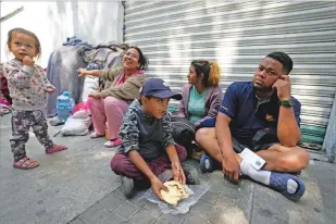  ?? FERNANDO LLANO/THE ASSOCIATED PRESS ?? A migrant family from Venezuela eats breakfast Tuesday alongside railroad tracks in Mexico City.