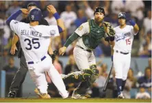  ?? Sean M. Haffey / Getty Images ?? Cody Bellinger of the Dodgers scores on a Logan Forsythe double in the sixth inning. Jonathan Lucroy awaits the throw.