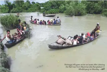  ?? — AFP ?? Rohingya refugees arrive on boats after crossing the Naf river from Myanmar into Bangladesh in Whaikhyang on Monday.