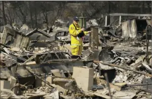  ?? PHOTO/ERIC RISBERG ?? A Cal Fire official looks out at the remains of the Journey’s End mobile home park Wednesday in Santa Rosa. Blazes burning in Northern California have become some of the deadliest in state history. AP