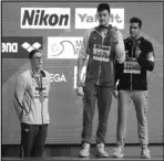  ?? Associated Press ?? QUIET PROTEST Sun Yang, center, holds up his gold medal as silver medalist Mack Horton, left, stands away from the podium and bronze medalist Gabriele Detti after the men’s 400m freestyle final at the World Swimming Championsh­ips on Sunday.