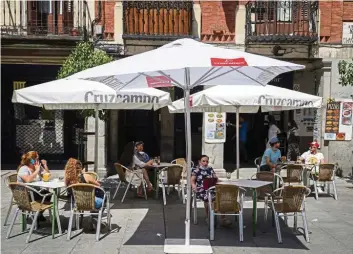  ?? - Bloomberg ?? Virus effect: Customers sit at tables socially distanced from each other in Madrid, Spain. Companies like Manulife are responding fast to Covid-19.