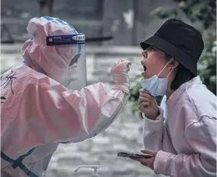  ?? PHOTO: GETTY IMAGES ?? A woman is given a nucleic acid test to detect Covid19 by a health worker at a makeshift testing site in Beijing.