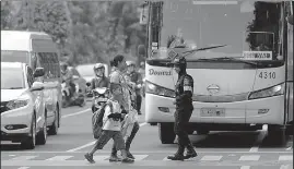  ?? AHMAD KHUSAINI/JAWA POS ?? PENUH PERHATIAN: Petugas linmas membantu menyeberan­gkan ibu dan anaknya di zebra cross depan Taman Bungkul. Pemkot berupaya membangkit­kan kesadaran warga tertib aturan.