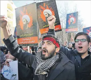  ?? AP PHOTO ?? Iranian demonstrat­ors chant slogans during a protest denouncing the execution of Sheikh Nimr al-Nimr, a prominent opposition Shiite cleric in Saudi Arabia, seen in posters, in front of the Saudi Embassy, in Tehran, Sunday.