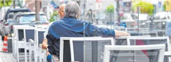  ?? FOTO: DPA ?? Ein Gast und der Café-Inhaber Ronald Boland sitzen in Mannheim im sogenannte­n Parklet. Das sind weitere Sitzplätze für Gäste des „Cafe Boland's“am Straßenran­d. Ansonsten wären dort Parkplätze für Autos.
