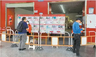  ?? Reuters-Yonhap ?? A man browses open factory job openings advertised at Shenzhen’s main factory recruitmen­t hub in Longhua district, Guangdong province, China, Oct. 20.