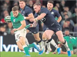  ??  ?? New Scotland captain Stuart Hogg attempts to get to grips with Ireland’s Jordan Larmour in Dublin