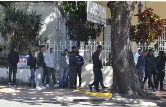  ?? F. DE LA CRUZ ?? Un grupo de hombres vestidos de negro se apostó en las afueras de CARD.