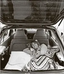  ?? TOM ERVIN / THE PALM BEACH POST 1984 ?? Julie Dunn of Lake Park relaxes in her hatchback, waiting for parcels to be sold in The Bluffs community.