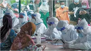  ?? — ZULAZHAR SHEBLEE ?? Not taking chances: Villagers from Kampung Bako hilir registerin­g for a swab test at the village.