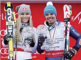  ?? — AP ?? ST MORITZ: In this March 16, 2016, file photo, Lindsey Vonn, of the United States, and Peter Fill, of Italy, hold the downhill cups at the Alpine Ski World Cup Finals.