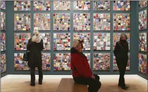  ?? (NWA Democrat-Gazette/Charlie Kaijo) ?? Demara Titzer of Bella Vista (from left), and Larry Fortner and Lynn Fortner of Bentonvill­e look through the art installmen­t “Beaded Prayers Project,” on Friday at the Crystal Bridges Museum of American Art in Bentonvill­e. A new exhibit, titled Crafting America, opens today. More photos at arkansason­line.com/26crafting/.