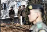  ?? LEE JIN-MAN — THE ASSOCIATED PRESS FILE ?? In this file photo, North Korean soldiers look at the South side as a South Korean stands guard near the spot where a North Korean soldier crossed the border on Nov. 13 at the Panmunjom, in the Demilitari­zed Zone, South Korea.