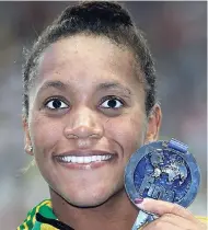  ??  ?? Jamaica’s Alia Atkinson holds her silver medal after her second-place finish in the women’s 50m breaststro­ke final at the Swimming World Championsh­ips in Kazan, Russia, yesterday.