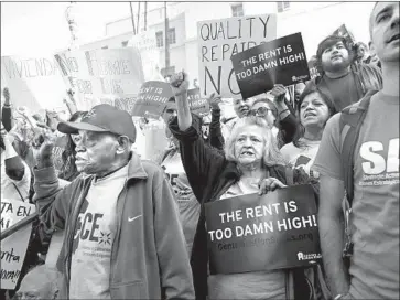  ?? Al Seib Los Angeles Times ?? JOE STRINGER, left, and Maria Gomez join advocates and tenants at a news conference on City Hall steps before the moratorium vote Tuesday. “It’s rather despicable what these landlords are doing,” said one activist.