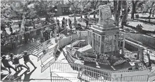  ??  ?? This image from police surveillan­ce video shows protesters pulling down the bottom tier of the obelisk on the Plaza.