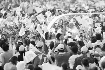  ?? — AFP photo ?? Pope Francis waves to the Catholic faithful as he arrives at the stadium where he is scheduled to say mass in Yangon.