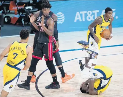  ?? ASHLEY LANDIS/AP ?? Indiana Pacers guard Victor Oladipo, right, falls to the floor after a hard foul during the game against the Miami Heat on Tuesday.