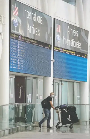  ?? [PETER J THOMPSON/NATIONAL POST ?? A man walks past posted warnings about COVID-19 at Toronto’s Pearson Internatio­nal Airport on Wednesday. Despite assurances from airlines, Canadians remain vulnerable to transnatio­nal diseases, writes John Ivison.