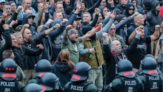  ?? © belga ?? Extreemrec­htse betogers in Chemnitz dagen de politie en linkse tegenbetog­ers uit.