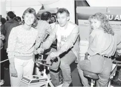  ??  ?? Everton footballer – and future Stoke City assistant-manager Peter Reid – on an exercise bike at the festival watched by, left, squash champion and current Sentinel columnist Angela Smith
