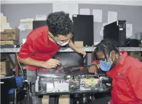  ??  ?? Joseph Keveany (left) and Matthew Esty perform repair work on an IT system