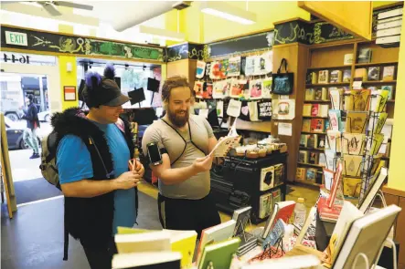  ?? Photos by Craig Lee / Special to The Chronicle ?? Customers known as Meow Meow (left) and Koyote browse at Booksmith in the Haight, which got a boost from the election.