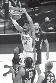  ?? JOSHUA A. BICKEL/COLUMBUS DISPATCH/USA TODAY NETWORK ?? Ohio State forward Justice Sueing (14) dunks over Oral Roberts forwards Kevin Obanor (0) and Francis Lacis (22) during the first half in the first round of the 2021 NCAA Tournament at Mackey Arena.